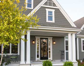 Front view of a typical mid-class home with gray James Hardie siding on its exterior